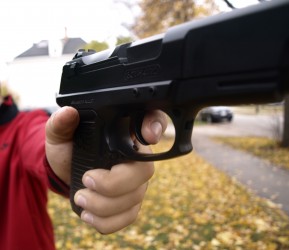 A person holds a gun as a representation. Photo by Martina Ibanez/angela.ibanez-baldor@marquette.edu