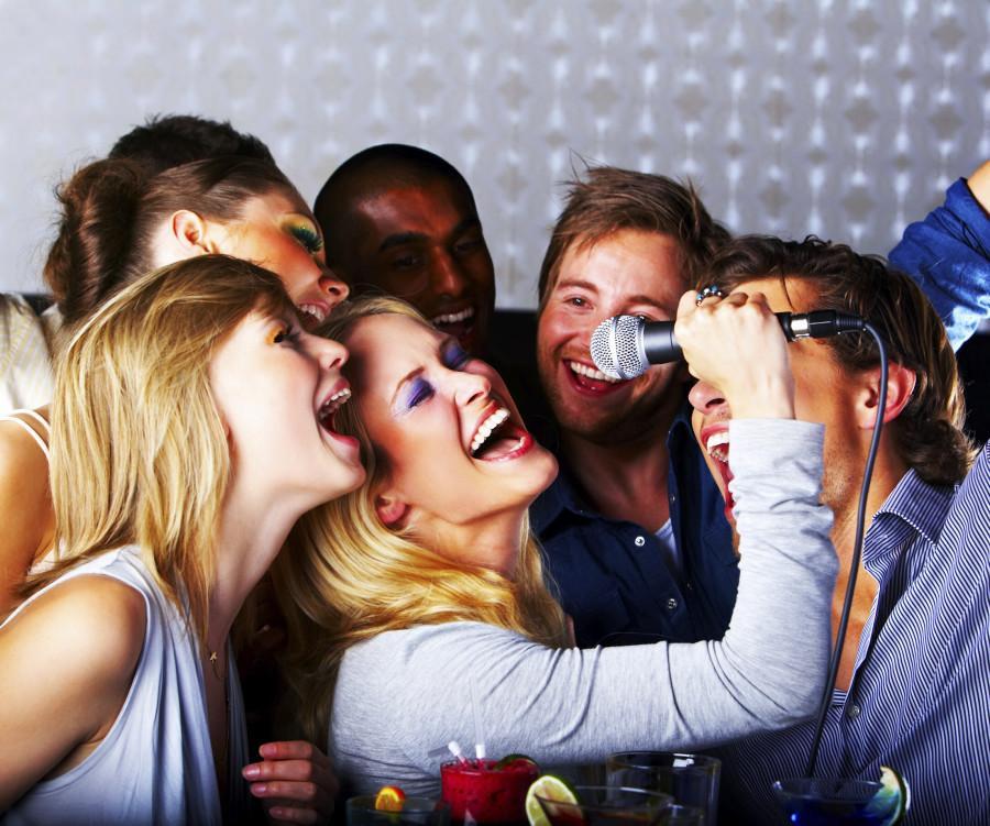 A group of young people singing at a karaoke party.