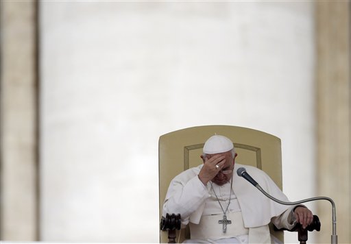 Pope Francis touches his forehead after delivering his message during the general audience in St. Peters Square, at the Vatican, Wednesday, April 9, 2014. Pope Francis has denounced the brutal slaying of an elderly Jesuit priest in Syria and called for an end to the violence. Photo by Gregorio Borgia / Associated Press.