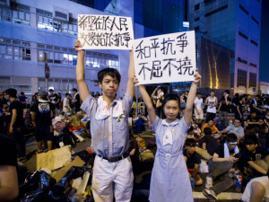 High school demonstrators hold signs during a protest outside the headquarters of Legislative Council in Hong Kong on Sept. 29, 2014.  Photo via nationalpost.com/XAUME OLLEROS/AFP/Getty Images