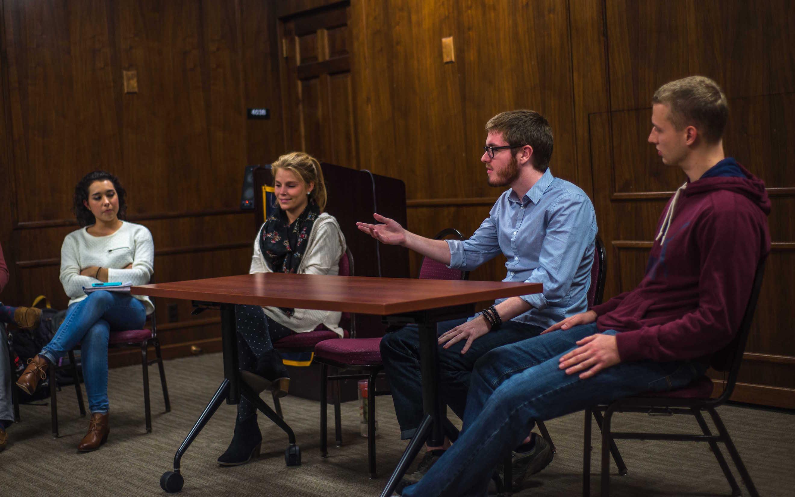 Students gather to talk about their experiences returning home after studying abroad. Left to right: Sophia Boyd, Monika Cinch, John Tobin, and Cody Bauer