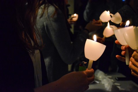 Students light each others candles at the vigil. Photo by Matt Serafin /matthew.serafin@mu.edu