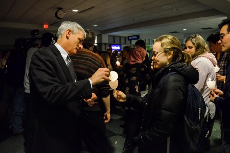 President Lovell lights a students' candle at the vigil. Photo by Matt Serafin /matthew.serafin@mu.edu