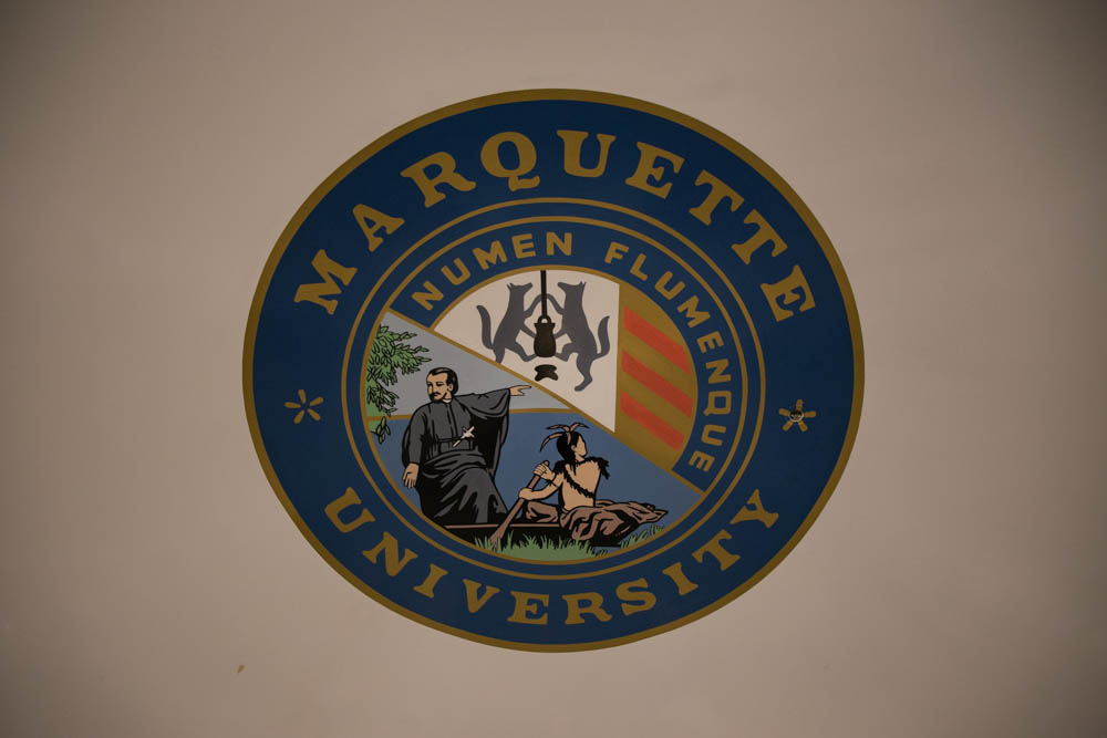 The Marquette seal, which features a cropped version of a painting depicting Jacques Marquette and a group of Native Americans, has sparked controversy over its revisionism.