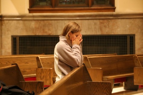 A student prays at the memorial Mass. Photo by Yue Yin/ yue.yin@marquette.edu