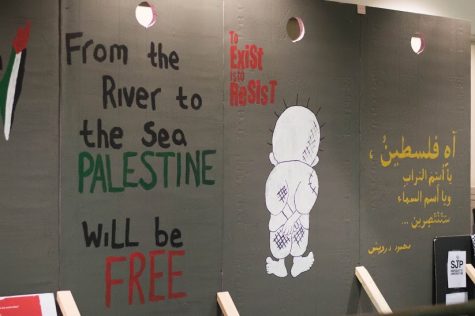 The wall displays symbolic images and statements about the Israeli-Palestine conflict, including “to exist is to resist.” Photo by Meredith Gillespie/meredith.gillespie@marquette.edu