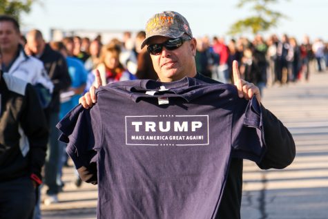 Trump supporter selling t-shirts in the line.