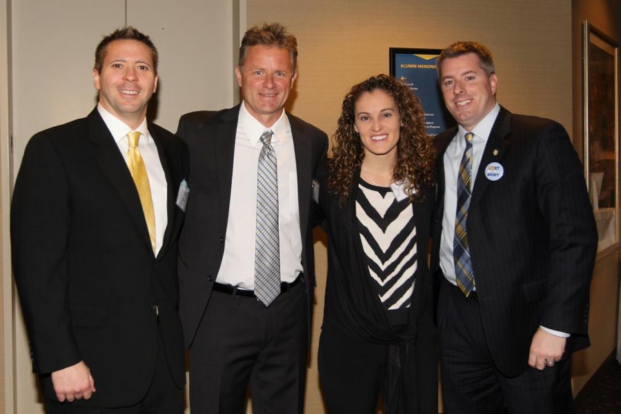 Deputy athletics director Brian Hardin (right) poses with volleyball coach Ryan Theis, womens soccer coach Markus Roeders and womens basketball coach Carolyn Kieger. (Photo courtesy of Marquette Athletics.)