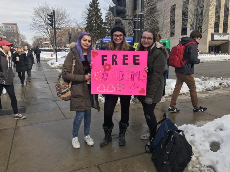 Some students, including freshman Calista Lopez (left), junior Kim Griesenauer (middle) and freshman Julia Meyer, handed out condoms in front of Raynor Memorial Libraries. The other side of their sign read, No Glove, No Love.