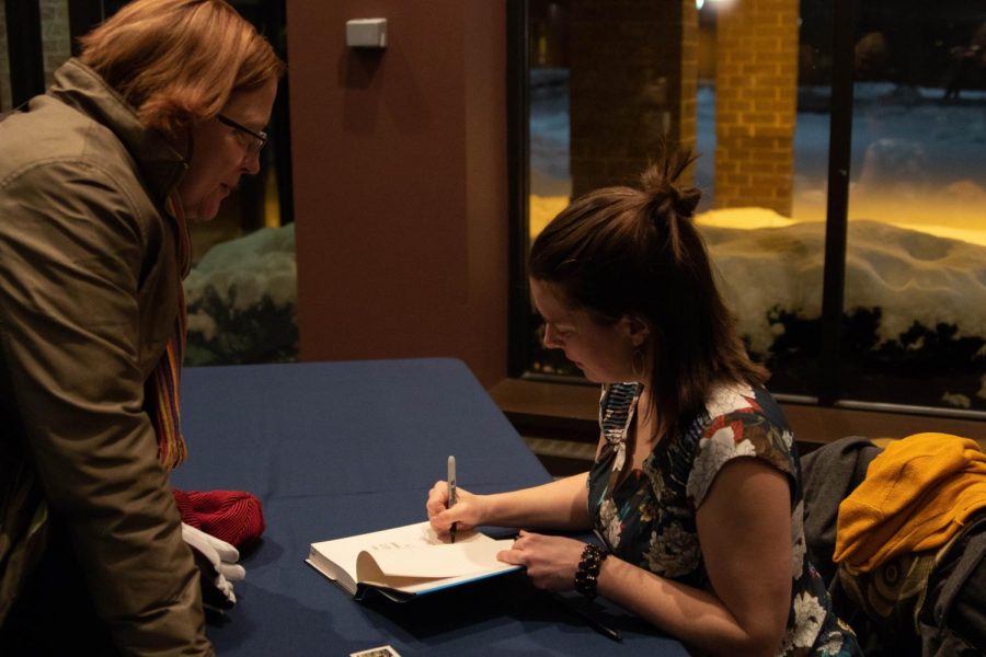 Anna Clark signs a copy of her book The Poisoned City: Flints Water and the American Urban Tragedy