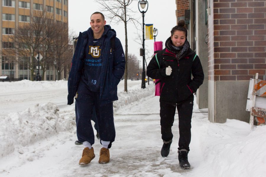 Mikey Zadroga (left), s senior in the College of Communication, and Megan Cote, a senior in the College Health Sciences, walk along 16th Street Monday morning.