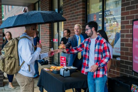 President Lovell hands out free breakfast sandwiches at Sendiks Fresh2GO on the first day of classes