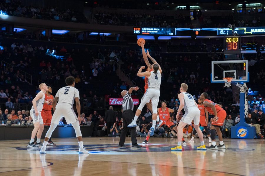 Marquette's then-sophomore center Theo John, center, tips off against St. John's in the 2019 BIG EAST Tournament.