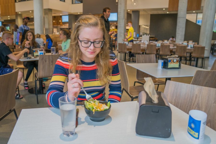 Lily+Wieringa%2C+a+junior+in+the+College+of+Arts+%26+Sciences%2C+eats+a+salad+in+The+Commons+dining+hall.