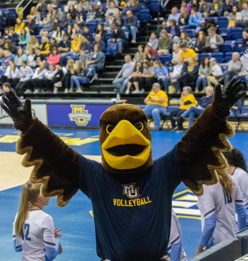 The mascot cheers at a womens volleyball game. 