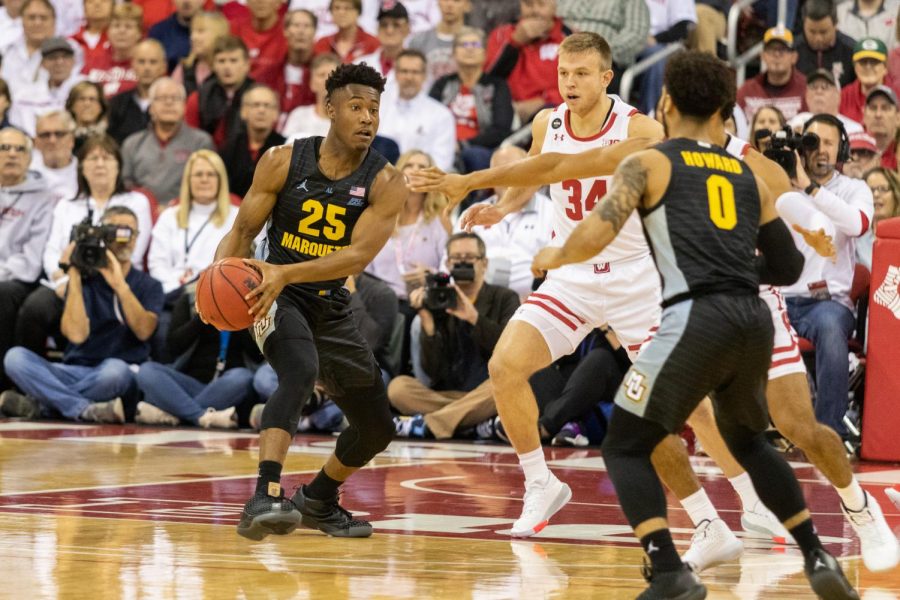 Redshirt junior guard Koby McEwen (25) passes the ball to teammate and senior guard Markus Howard (0) in MUs 77-61 loss to Wisconsin Nov. 17 at the Kohl Center in Madison.