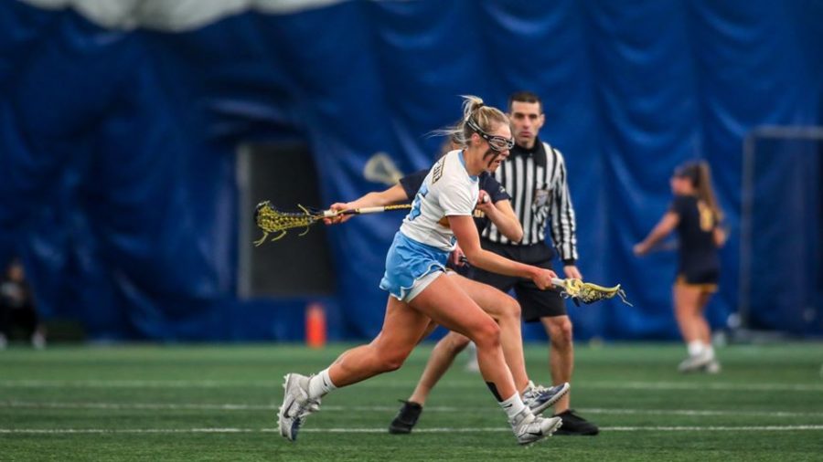 Emily+Cooper+%2835%29+heads+towards+the+net+with+a+Canisius+defender+on+her.+Cooper+scored+three+goals+and+won+six+draw+controls+in+MUs+18-11+win.+%28Photo+courtesy+of+Marquette+Athletics.%29
