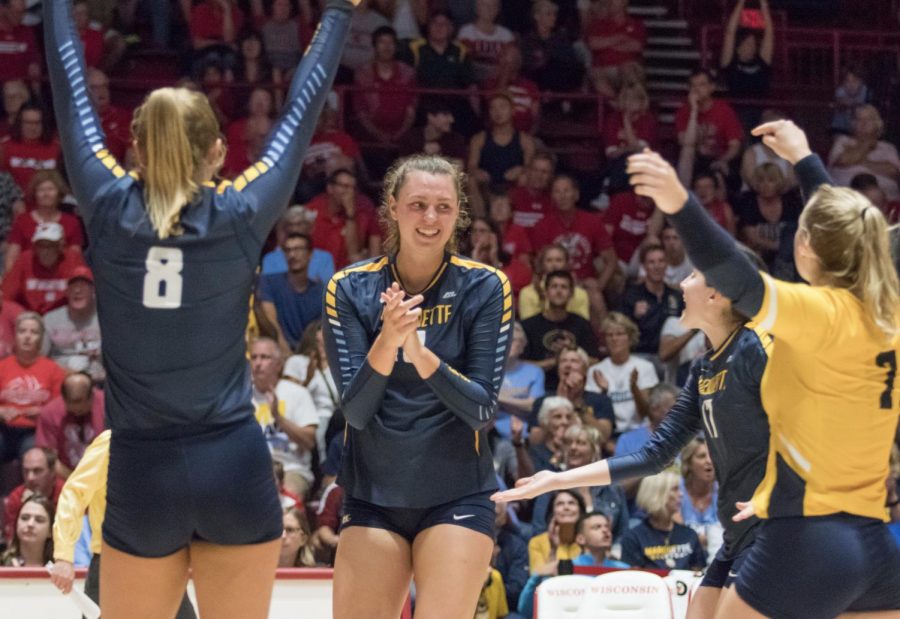 Allie+Barber+celebrates+with+teammates+Hope+Werch+%288%29%2C+Katie+Schoessow+%2817%29%2C+and+Martha+Konovodoff+%287%29+in+a+match+against+Wisconsin.+