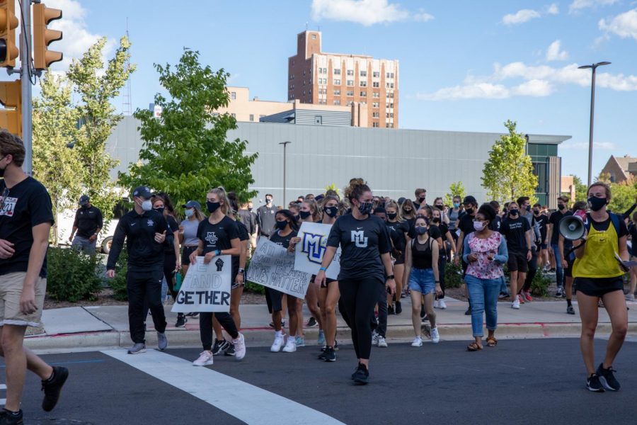 Erin Scott (front, MU short-sleeve t-shirt) walks with the womens soccer team during the athletes march Sept. 4. (Photo courtesy of Marquette Athletics.)