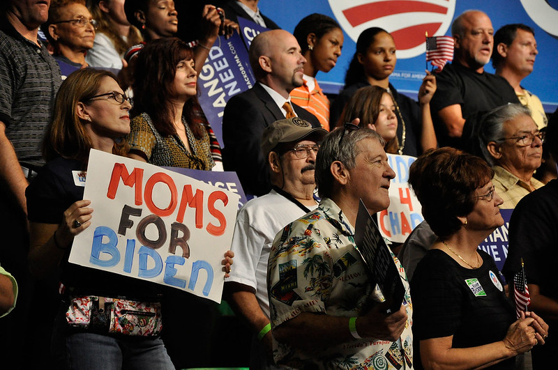 Biden supporters stand together holding signs.  Photo via Flickr
