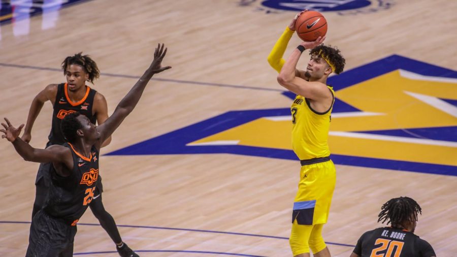 First-year forward Dawson Garcia attempts a shot over Oklahoma State sophomore forward Bernard Kouma (25) (Photo courtesy of Marquette Athletics).