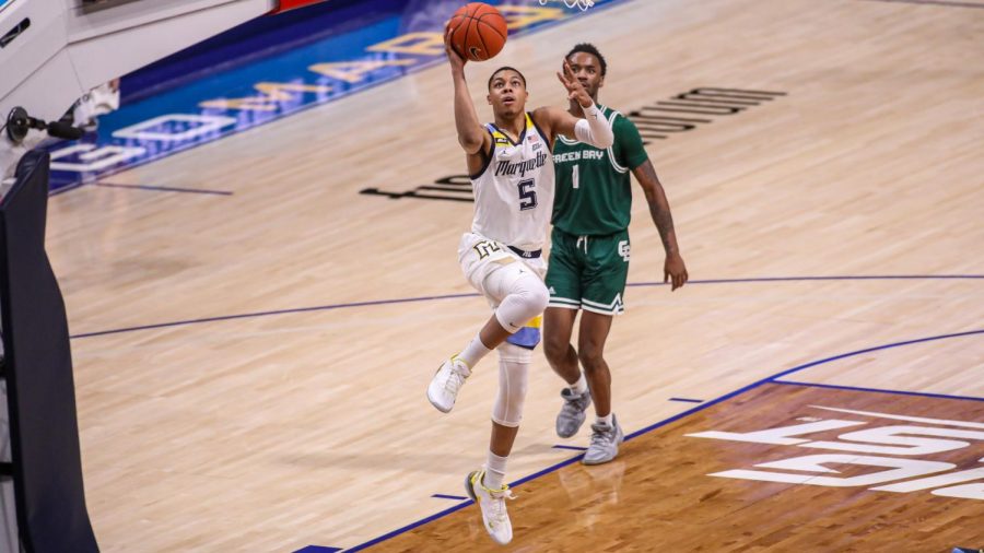 Redshirt+junior+guard+Greg+Elliott+%285%29+goes+up+for+a+layup+in+front+of+Green+Bay+sophomore+guard+Amari+Davis+%281%29+%28Photo+courtesy+of+Marquette+Athletics.%29