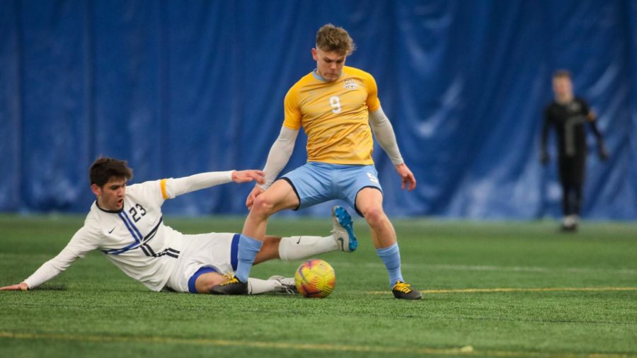 Junior forward Lukas Sunesson (9) shakes off a slide tackle (Photo courtesy of Marquette Athletics.)
