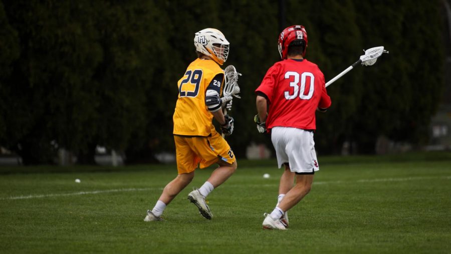 Redshirt first-year attacker Devon Cowan (29) works his way past a St. Johns defender April 14. He scored the game-winning goal in the fourth overtime period Saturday afternoon (Photo courtesy of Marquette Athletics.)