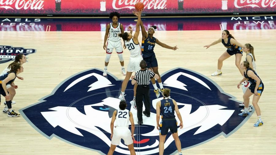 Forward Camryn Taylor (15) goes up for a jump ball against the UConn Huskies (Photo courtesy of Marquette Athletics.)