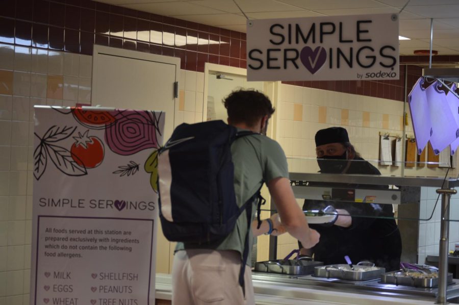 A student receiving food from the Simple Servings station 