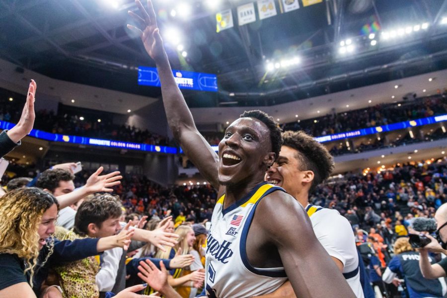 Kur Kuath (front) and Oso Ighodaro (back) celebrating with the Marquette student section after mens basketballs 67-66 win over No. 10 Illinois Nov. 15. 