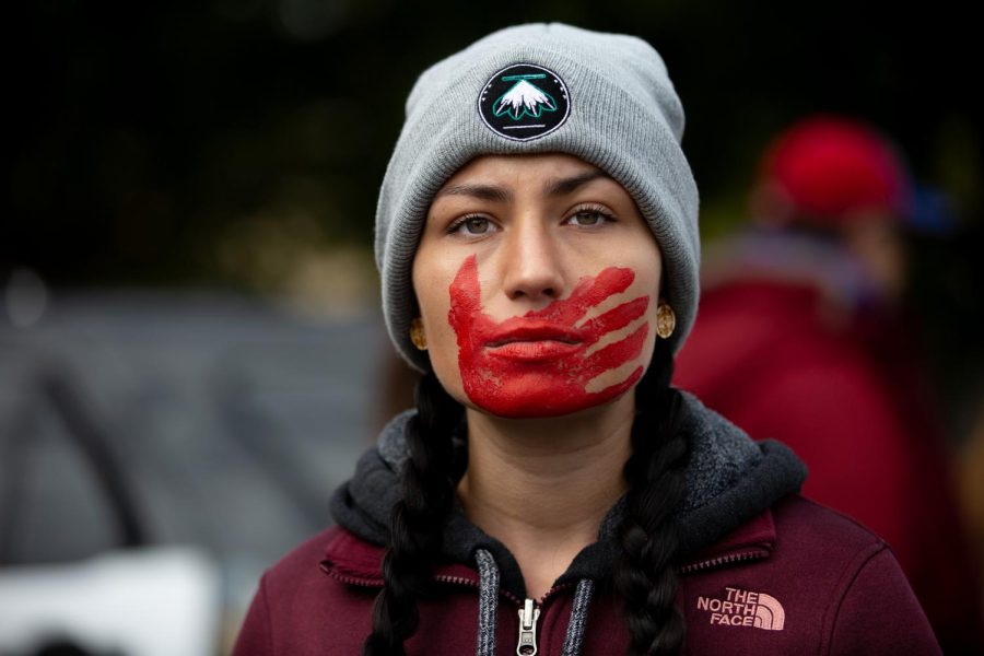 A protestor at the 2018 Greater Than Fear march in Rochester, Minnesota wears a red painted handprint on her face, a symbol of the MMIW movement for the women who have been silenced. Photo via Flickr