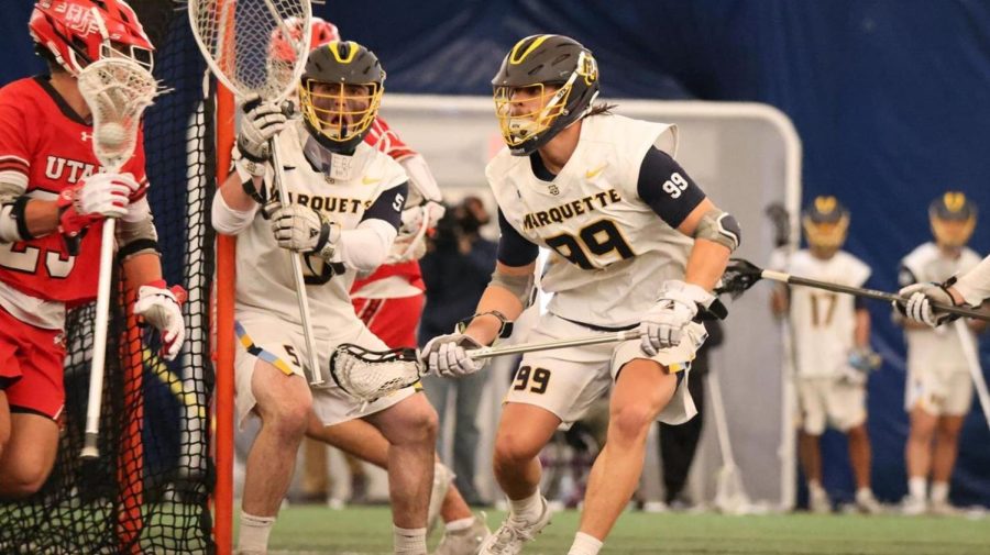 Graduate student midfielder Anthony Courcelle (99) defends a Utah player in Marquette mens lacrosses 12-11 loss to the Utes Feb. 26. (Photo courtesy of Marquette Athletics.)