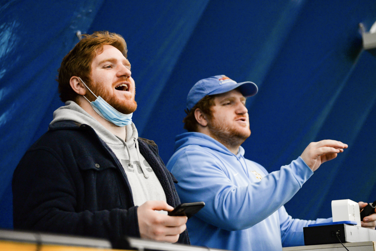 Nick and Joey Artinian cheer for the mens lacrosse team from the sidelines.