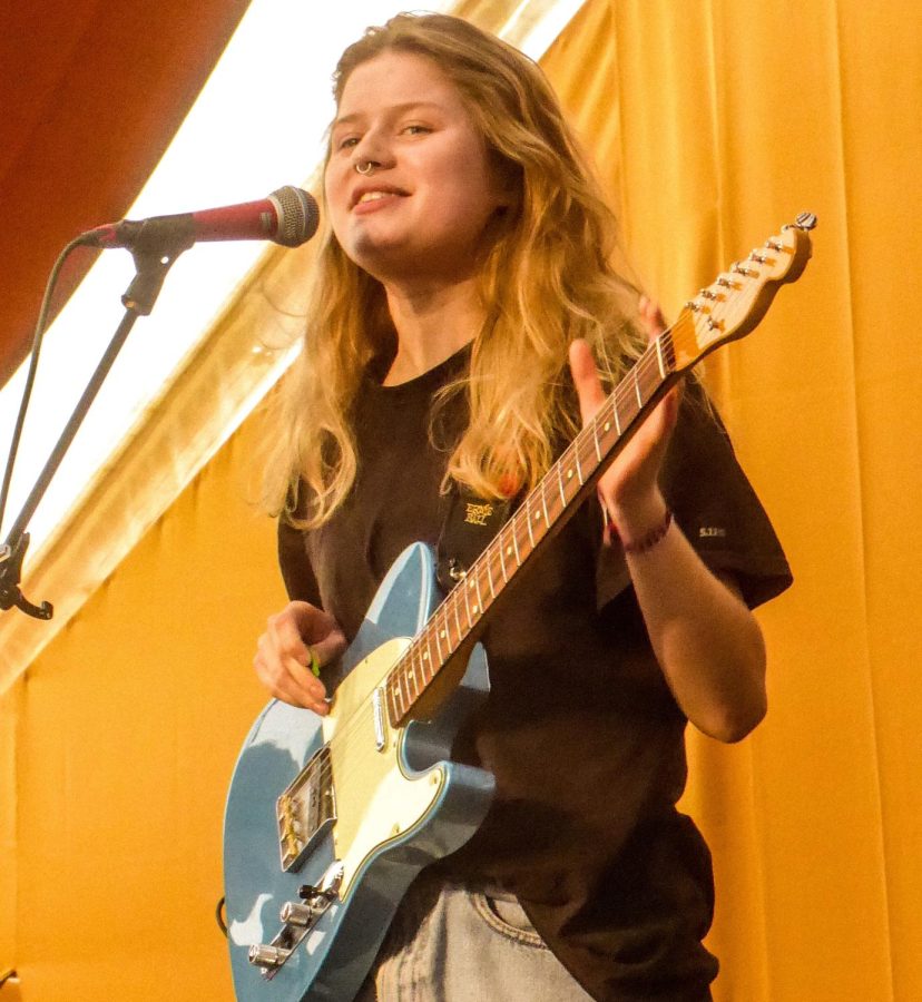 Indie artist girl in red performs at the End of the Road music festival in 2019. 