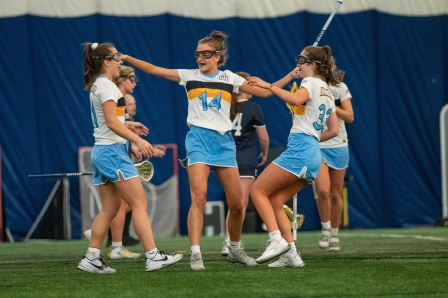 Shea Garcia (left), Mary Schumar (center) and Meg Bireley (right) celebrate after a goal in Marquette womens lacrosses 24-17 win over Butler April 16. 