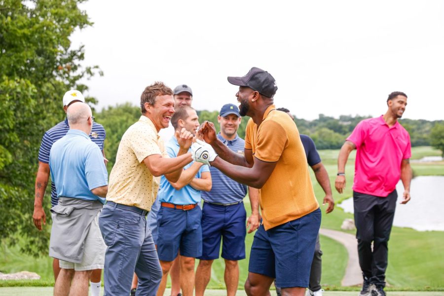 Travis+Diener+%28left%29+and+Dwayne+Wade+%28right%29+embrace+during+the+M+Club+Golf+Outing+Aug.+8+at+The+Legend+at+Brandybrook+golf+course.+%28Photo+courtesy+of+Marquette+Athletics.%29