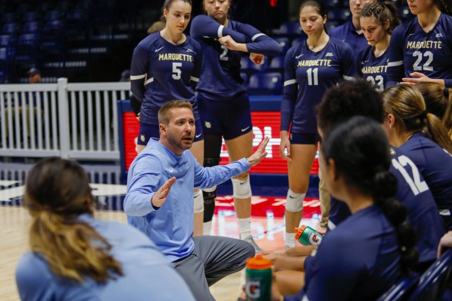 Marquette head coach Ryan Theis (center) talking to his team in its 3-0 win at Xavier Oct. 16. (Photo courtesy of Marquette Athletics.)