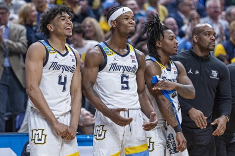 Stevie Mitchell (4), Chase Ross (5) and Sean Jones (22) celebrate from Marquettes bench during its win over Vermont in the first round of the NCAA Tournament March 18 at Nationwide Arena in Columbus, Ohio. (Photo courtesy of Marquette Athletics.)