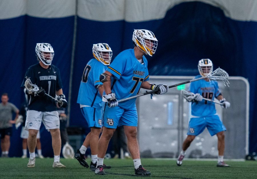 Mason Woodward (77) on defense in Marquette mens lacrosses 15-14 loss to No. 9 Georgetown April 15.