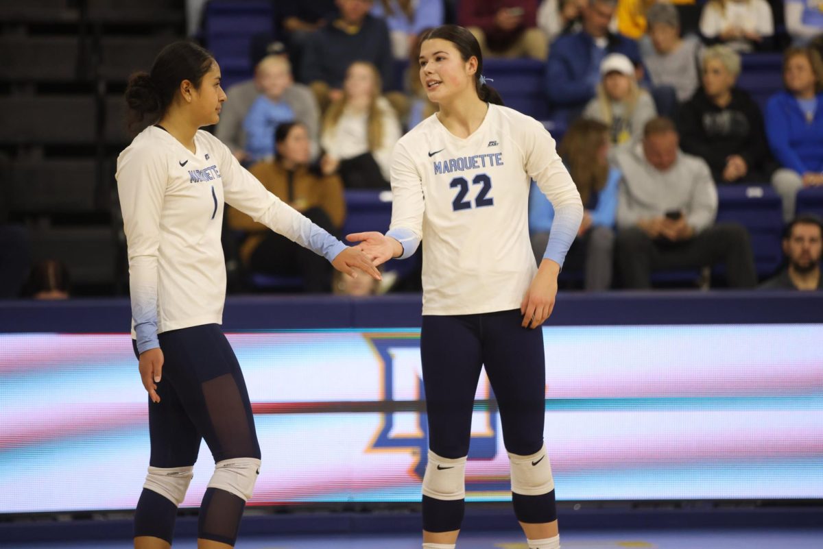 Middle blocker Hattie Bray (22) and setter Yadhira Anchante (1) high-five in Marquettes 3-2 loss to St. Johns Friday, Nov. 24 at the Al McGuire Center. (Photo courtesy of Marquette Athletics.)