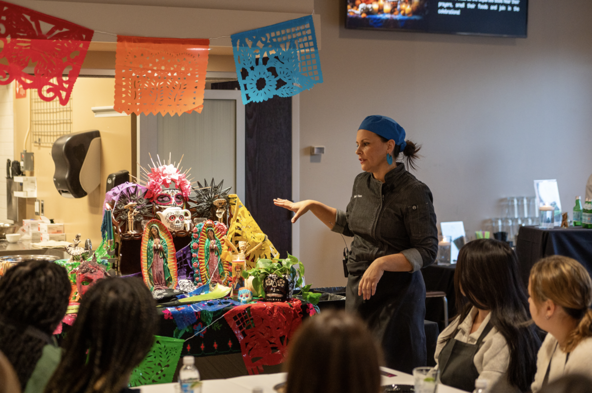 Melanie Vianes demonstrates how to prepare the Tamales in front of the Ofrenda. 