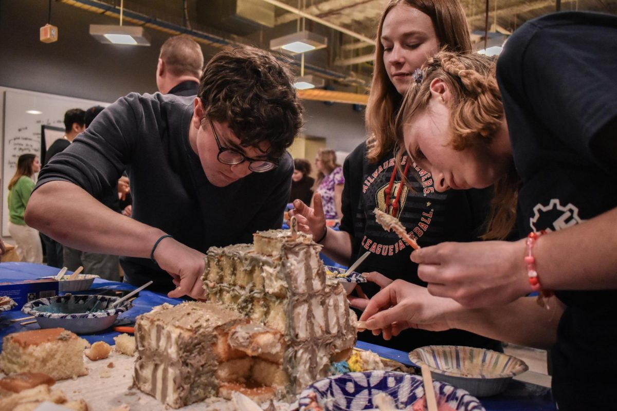 A team of engineering students work to create a Marquette inspired cake at the annual Cake Wars.
