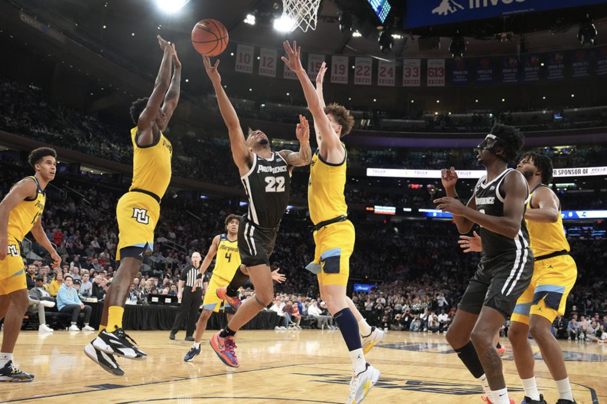 Ben Gold (right) and Kam Jones (left) defend Providences Devin Carter in Marquettes 78-69 win over Providence in the Big East Tournament semifinals. (Photo courtesy of Marquette Athletics.)