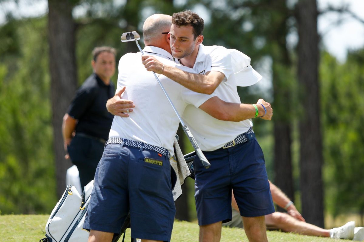 Aidan Lafferty (right) hugs Marquette mens golf head coach Steve Bailey at the Big East Tournament. (Photo courtesy of Marquette Athletics.)