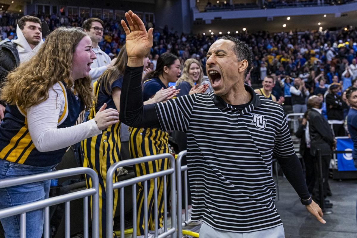 Shaka Smart celebrates with students after beating No. 22 Creighton 72-67, Dec. 30, 2023.