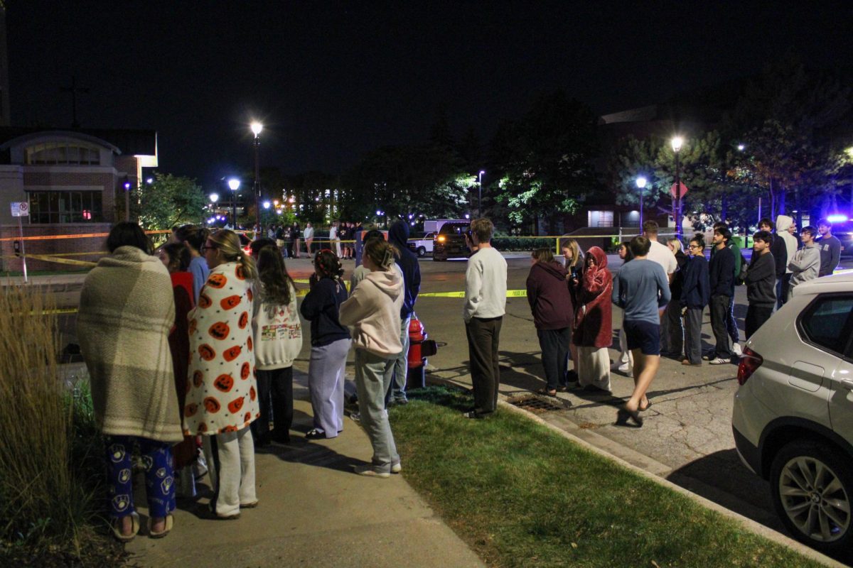 Students watching the aftermath of the car crash in front of Evans Scholars House.