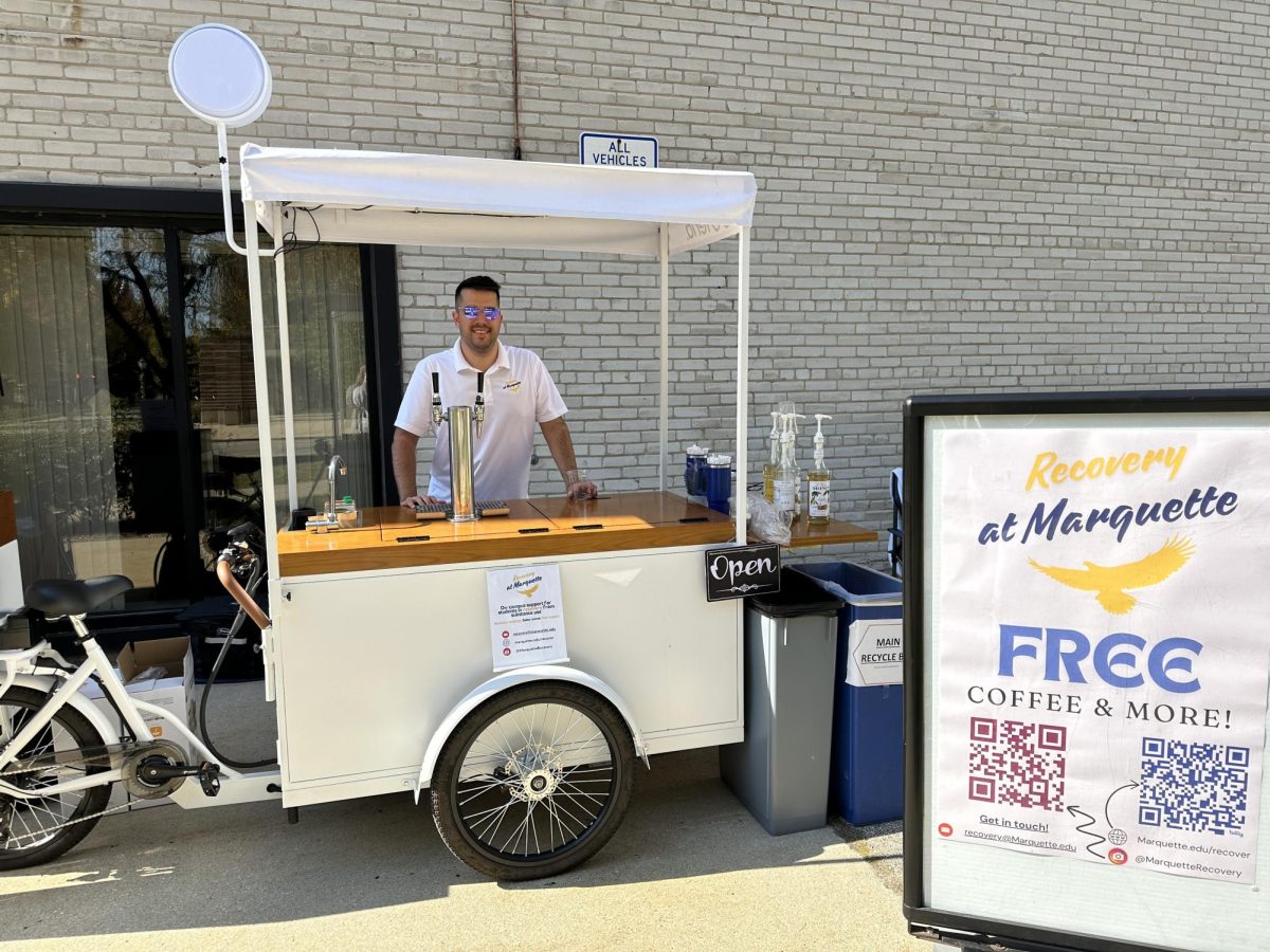 Timothy Rabolt, manager of the Collegiate Recovery Program, hands out free coffee and treats to raise awareness of substance use recovery.