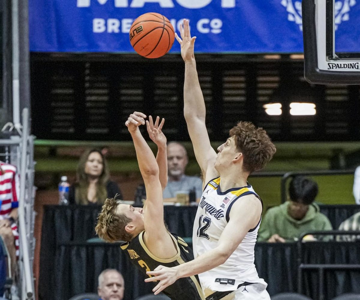 Ben Gold (right) blocks Fletcher Loyer's (left) shot attempt during the Maui Invitational Final on Nov. 22, 2023. (Photo courtesy of Marquette Athletics).