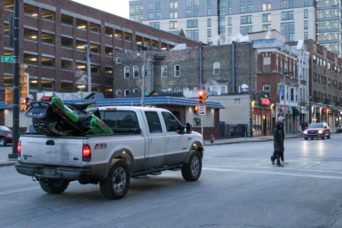 A truck carrying a snowmobile drives west through campus on January 21.